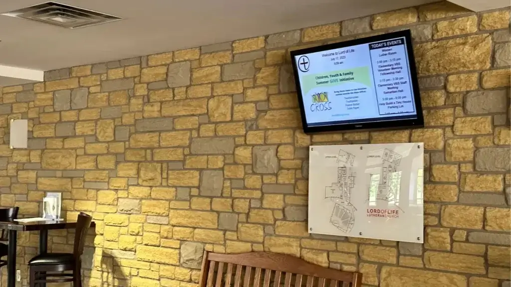 Church digital signage by Reach Media Network featured in lobby, above building map.