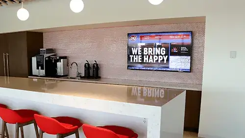 Dairy Queen digital signage lobby example from Reach Media Network displaying traffic radar, news headlines, and announcements