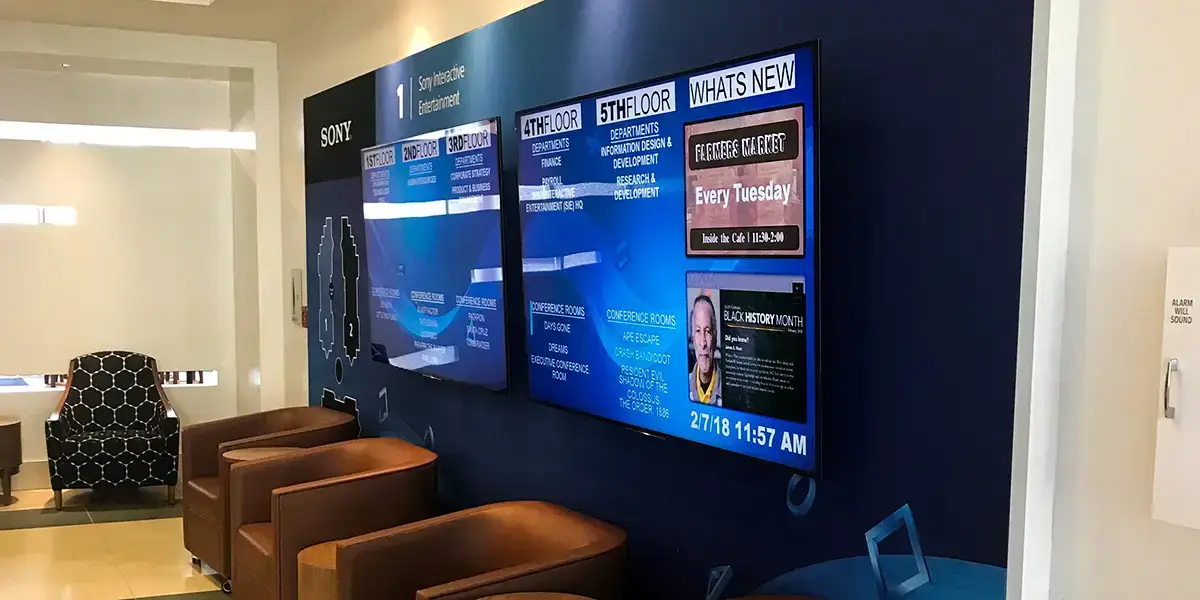 Sony Interactive Entertainment digital signage video wall from Reach Media Network featured in lobby, displaying departments by floor and 'What's New' announcements.