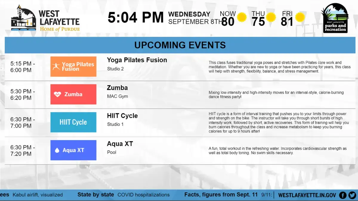 West Lafayette digital signage screen from Reach Media Network displaying upcoming fitness class events and government metrics ticker.